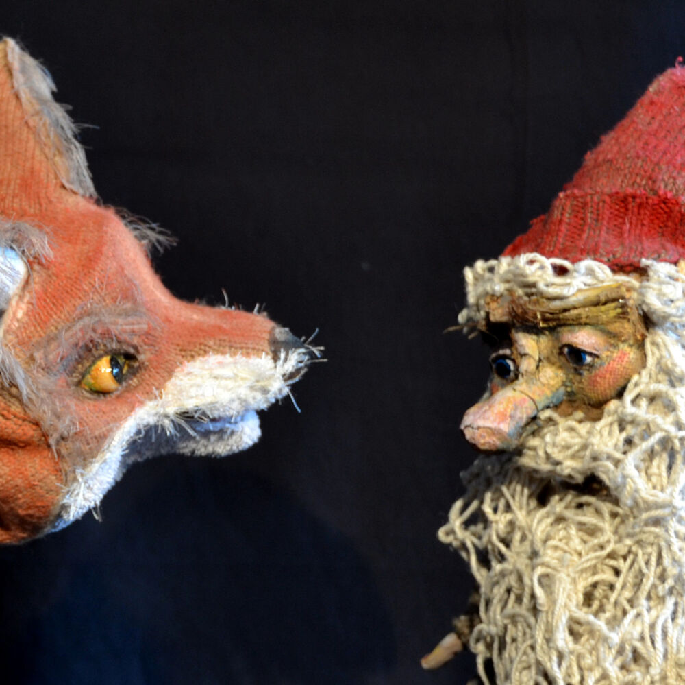 Ein Fuchs und ein kleiner Zwerg mit Bart und roter Mütze stehen sich gegenüber
